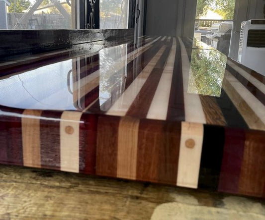 A close-up view of a long wooden epoxy countertop with striped wood.