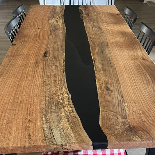 A wooden table with an epoxy river vein, finely sanded down.